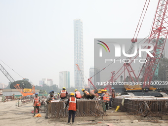 Labourers work at a metro railway station construction site in Kolkata, India, on November 22, 2024. (