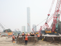 Labourers work at a metro railway station construction site in Kolkata, India, on November 22, 2024. (