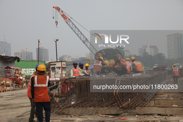 Labourers work at a metro railway station construction site in Kolkata, India, on November 22, 2024. 