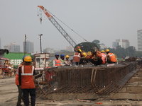 Labourers work at a metro railway station construction site in Kolkata, India, on November 22, 2024. (