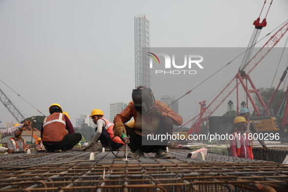 Labourers work at a metro railway station construction site in Kolkata, India, on November 22, 2024. 