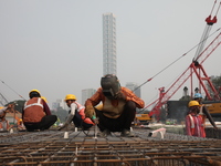 Labourers work at a metro railway station construction site in Kolkata, India, on November 22, 2024. (