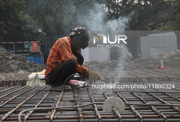 A laborer works at a metro railway station construction site in Kolkata, India, on November 22, 2024. 