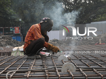 A laborer works at a metro railway station construction site in Kolkata, India, on November 22, 2024. (