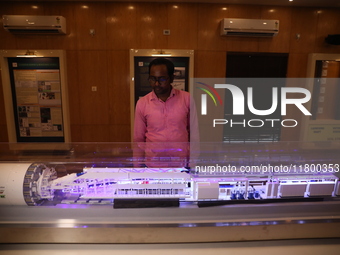 A worker looks at a model of a metro railway station at a construction site in Kolkata, India, on November 22, 2024. (