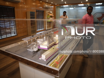 A worker looks at a model of a metro railway station at a construction site in Kolkata, India, on November 22, 2024. (