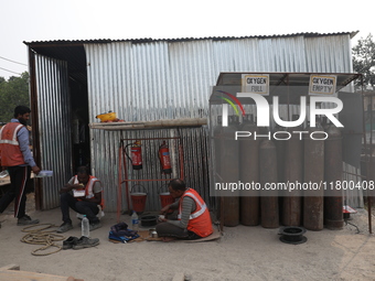 Labourers eat their food at a metro railway station construction site in Kolkata, India, on November 22, 2024. (