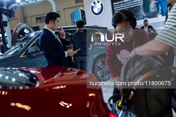 Visitors look at BMW's electric vehicles displayed during The Gaikindo Jakarta Auto Week in Tangerang, Indonesia, on November 22, 2024. The...