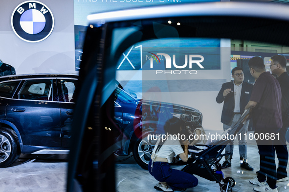 Visitors look at BMW's electric vehicles displayed during The Gaikindo Jakarta Auto Week in Tangerang, Indonesia, on November 22, 2024. The...