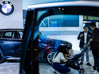 Visitors look at BMW's electric vehicles displayed during The Gaikindo Jakarta Auto Week in Tangerang, Indonesia, on November 22, 2024. The...