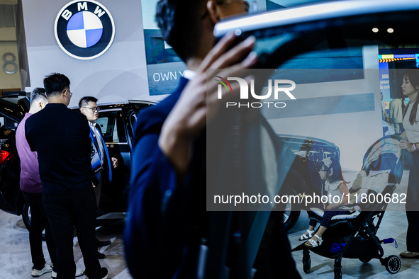 Visitors look at BMW's electric vehicles displayed during The Gaikindo Jakarta Auto Week in Tangerang, Indonesia, on November 22, 2024. The...