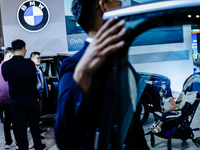 Visitors look at BMW's electric vehicles displayed during The Gaikindo Jakarta Auto Week in Tangerang, Indonesia, on November 22, 2024. The...