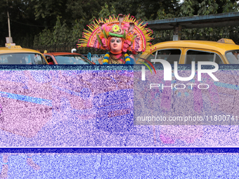 Indian tribal Chaw artists from Purulia stand in front of a Yellow Ambassador Taxi during the West Bengal Government-hosted ''Jangalmahal Ut...