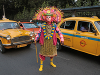 Indian tribal Chaw artists from Purulia stand in front of a Yellow Ambassador Taxi during the West Bengal Government-hosted ''Jangalmahal Ut...