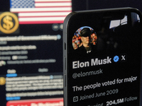 The photo shows Elon Musk’s personal X account displayed on an iPhone in the foreground, while the official X profile of the Department of G...