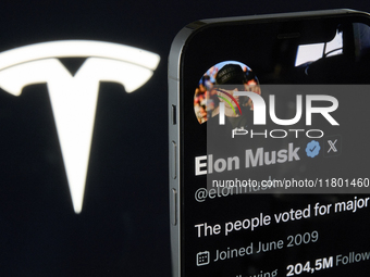 The image shows Elon Musk's personal X profile displayed on an iPhone, with the Tesla logo, his electric vehicle company, subtly visible in...