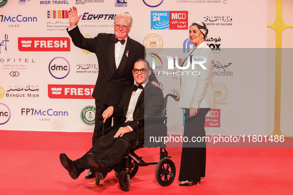 Movie star Hassen Fahmiii stands with one of the attendees with special needs on the red carpet at the conclusion of the Cairo Film Festival...