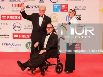 Movie star Hassen Fahmiii stands with one of the attendees with special needs on the red carpet at the conclusion of the Cairo Film Festival...