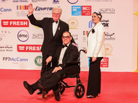 Movie star Hassen Fahmiii stands with one of the attendees with special needs on the red carpet at the conclusion of the Cairo Film Festival...