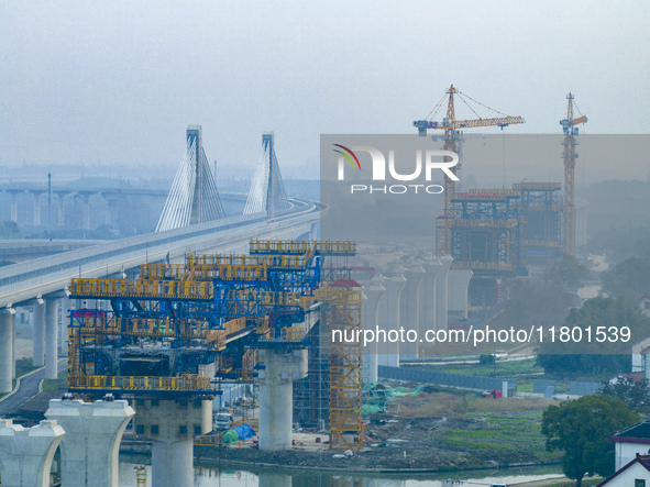 In Shanghai, China, on November 22, 2024, a photo shows the Shanghai Demonstration Zone Line crossing the Highway Port Bridge under construc...