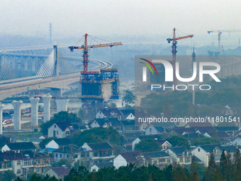 In Shanghai, China, on November 22, 2024, a photo shows the Shanghai Demonstration Zone Line crossing the Highway Port Bridge under construc...