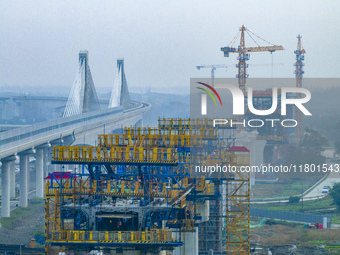 In Shanghai, China, on November 22, 2024, a photo shows the Shanghai Demonstration Zone Line crossing the Highway Port Bridge under construc...