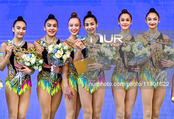 Gold medalists Team Uzbekistan celebrate on the podium after the Group Exercises 5 Hoops Final of the International Rhythmic Gymnastics Tour...