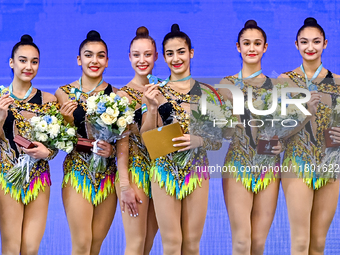 Gold medalists Team Uzbekistan celebrate on the podium after the Group Exercises 5 Hoops Final of the International Rhythmic Gymnastics Tour...