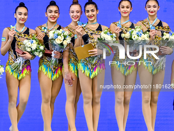 Gold medalists Team Uzbekistan celebrate on the podium after the Group Exercises 5 Hoops Final of the International Rhythmic Gymnastics Tour...