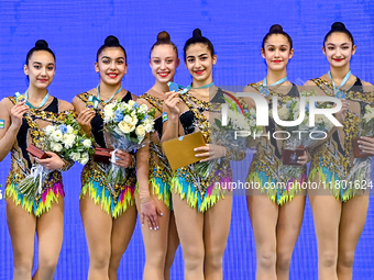 Gold medalists Team Uzbekistan celebrate on the podium after the Group Exercises 5 Hoops Final of the International Rhythmic Gymnastics Tour...