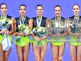 Gold medalists Team ORSS No16 from Russia celebrate on the podium after the Group Exercises 3 ribbons 2 balls Final of the International Rhy...