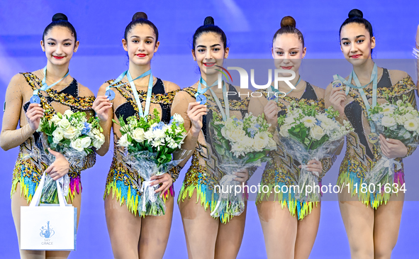 Silver medalist Team Uzbekistan celebrates on the podium after the Group Exercises 3 ribbons 2 balls Final of the International Rhythmic Gym...