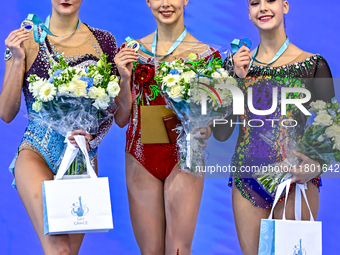 Gold medalist Mariia Borisova of Russia, silver medalist Alina Harnasko of Belarus, and bronze medalist Natalya Usova of Uzbekistan celebrat...