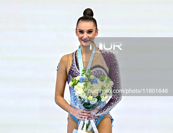 Gold medalist Alina Harnasko of Belarus celebrates on the podium after the Individual Hoop Final of the International Rhythmic Gymnastics To...