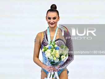 Gold medalist Alina Harnasko of Belarus celebrates on the podium after the Individual Hoop Final of the International Rhythmic Gymnastics To...