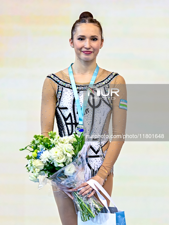 Silver medalist Takhmina Ikromova of Uzbekistan celebrates on the podium after the Individual Hoop Final of the International Rhythmic Gymna...