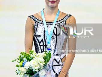 Silver medalist Takhmina Ikromova of Uzbekistan celebrates on the podium after the Individual Hoop Final of the International Rhythmic Gymna...