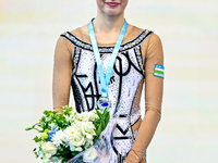 Silver medalist Takhmina Ikromova of Uzbekistan celebrates on the podium after the Individual Hoop Final of the International Rhythmic Gymna...