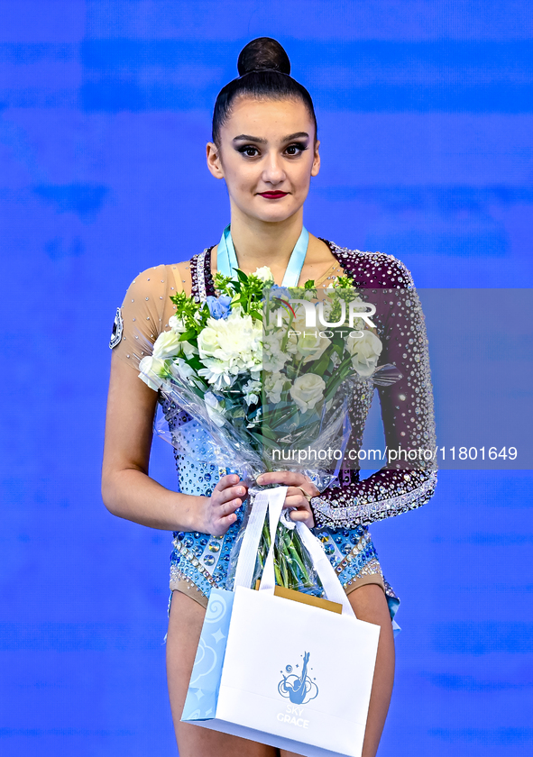 Gold medalist Alina Harnasko of Belarus celebrates on the podium after the Individual Hoop Final of the International Rhythmic Gymnastics To...