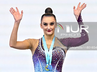 Gold medalist Alina Harnasko of Belarus celebrates on the podium after the Individual Ball Final of the International Rhythmic Gymnastics To...