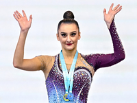 Gold medalist Alina Harnasko of Belarus celebrates on the podium after the Individual Ball Final of the International Rhythmic Gymnastics To...