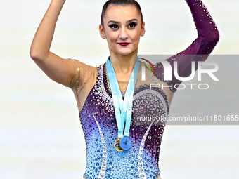 Gold medalist Alina Harnasko of Belarus celebrates on the podium after the Individual Ball Final of the International Rhythmic Gymnastics To...