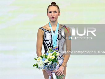 Bronze medalist Takhmina Ikromova of Uzbekistan celebrates on the podium after the Individual Ball Final of the International Rhythmic Gymna...