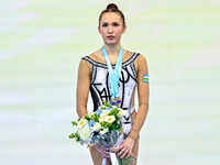 Bronze medalist Takhmina Ikromova of Uzbekistan celebrates on the podium after the Individual Ball Final of the International Rhythmic Gymna...