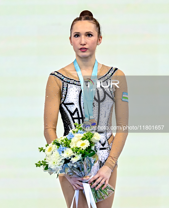 Bronze medalist Takhmina Ikromova of Uzbekistan celebrates on the podium after the Individual Ball Final of the International Rhythmic Gymna...