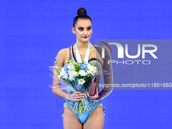 Gold medalist Alina Harnasko of Belarus celebrates on the podium after the Individual Ball Final of the International Rhythmic Gymnastics To...