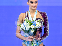 Gold medalist Alina Harnasko of Belarus celebrates on the podium after the Individual Ball Final of the International Rhythmic Gymnastics To...