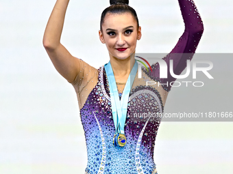 Gold medalist Alina Harnasko of Belarus celebrates on the podium after the Individual Clubs Final of the International Rhythmic Gymnastics T...