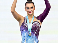 Gold medalist Alina Harnasko of Belarus celebrates on the podium after the Individual Clubs Final of the International Rhythmic Gymnastics T...