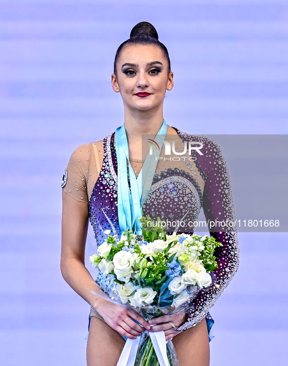 Gold medalist Alina Harnasko of Belarus celebrates on the podium after the Individual Clubs Final of the International Rhythmic Gymnastics T...